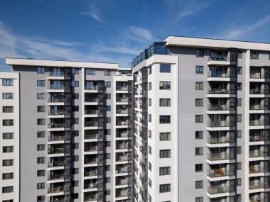 Balkonları ve açık hava alanları olan modern konut binalarının havadan görünüşü. Dairelerin temiz, geometrik tasarımı çağdaş şehir yaşamını ön plana çıkarıyor. İHA ile vurulmuş..