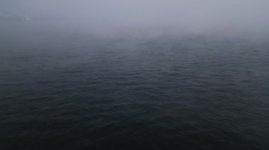 Sakin suda sisli bir gün, görüş mesafesi çok düşük. Sakin ve atmosferik deniz manzarası. Hava, ruh hali, doğa ve manzara görselleri için harika..