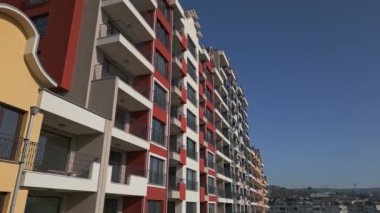 Renkli balkonları ve geometrik tasarımı olan modern konut binalarının insansız hava aracı görüntüsü, şehir planında kentsel mimari ve canlı cephe detaylarını yakalıyor..