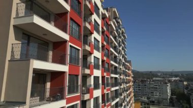 Renkli balkonları ve geometrik tasarımı olan modern konut binalarının insansız hava aracı görüntüsü, şehir planında kentsel mimari ve canlı cephe detaylarını yakalıyor..