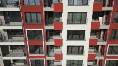 Renkli balkonları ve geometrik tasarımı olan modern konut binalarının insansız hava aracı görüntüsü, şehir planında kentsel mimari ve canlı cephe detaylarını yakalıyor..