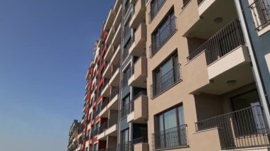 Renkli balkonları ve geometrik tasarımı olan modern konut binalarının insansız hava aracı görüntüsü, şehir planında kentsel mimari ve canlı cephe detaylarını yakalıyor..