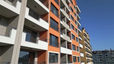 Renkli balkonları ve geometrik tasarımı olan modern konut binalarının insansız hava aracı görüntüsü, şehir planında kentsel mimari ve canlı cephe detaylarını yakalıyor..