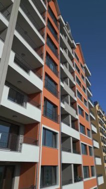 Renkli balkonları ve geometrik tasarımı olan modern konut binalarının insansız hava aracı görüntüsü, şehir planında kentsel mimari ve canlı cephe detaylarını yakalıyor..