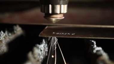 Bir CNC lazer kesme makinesi tam olarak metal bir levhayı keser ve parlak kıvılcımlar üretir. Bu endüstriyel süreç modern teknolojiyi ve yüksek teknoloji metalciliği sergiliyor.
