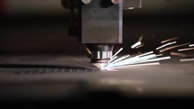 Bir CNC lazer kesme makinesi tam olarak metal bir levhayı keser ve parlak kıvılcımlar üretir. Bu endüstriyel süreç modern teknolojiyi ve yüksek teknoloji metalciliği sergiliyor.