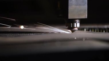 Bir CNC lazer kesme makinesi tam olarak metal bir levhayı keser ve parlak kıvılcımlar üretir. Bu endüstriyel süreç modern teknolojiyi ve yüksek teknoloji metalciliği sergiliyor.