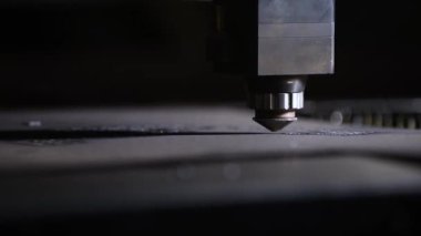 Bir CNC lazer kesme makinesi tam olarak metal bir levhayı keser ve parlak kıvılcımlar üretir. Bu endüstriyel süreç modern teknolojiyi ve yüksek teknoloji metalciliği sergiliyor.