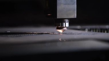 Bir CNC lazer kesme makinesi tam olarak metal bir levhayı keser ve parlak kıvılcımlar üretir. Bu endüstriyel süreç modern teknolojiyi ve yüksek teknoloji metalciliği sergiliyor.