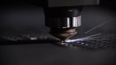Bir CNC lazer kesme makinesi tam olarak metal bir levhayı keser ve parlak kıvılcımlar üretir. Bu endüstriyel süreç modern teknolojiyi ve yüksek teknoloji metalciliği sergiliyor.