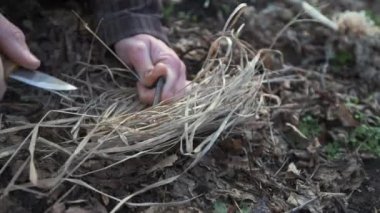 Bir adam kıvılcımlar çıkarmak için bıçak ve yangın başlatıcı kullanır ve kuru çimlerde ateş yakar. Bu hayatta kalma tekniği açık hava becerilerinin ve vahşi doğaya hazırlığın özünü yakalar..
