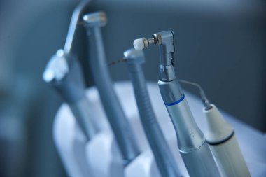 Çağdaş bir klinikte yapılacak bir prosedür için bir diş aletleri koleksiyonu düzgünce düzenlenir. Araçlar parlatılmış ve kullanıma hazır, profesyonel bir ortamı yansıtıyor.