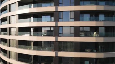 Çağdaş bir apartman kompleksi çoklu kıvrımlı balkonlara sahiptir, açık bir günde okyanusa bakan güneş ışığını yansıtır, kentsel yaşamı ve tasarımı gösterir..