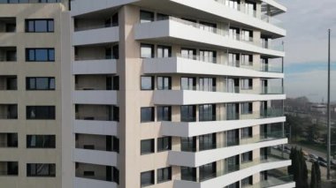 Çağdaş bir yerleşim yeri, birden fazla balkona sahip dalga benzeri bir cephe içerir. Büyük pencereler apartmanlara doğal ışık girmesini sağlarken şehir manzarası sunuyor.