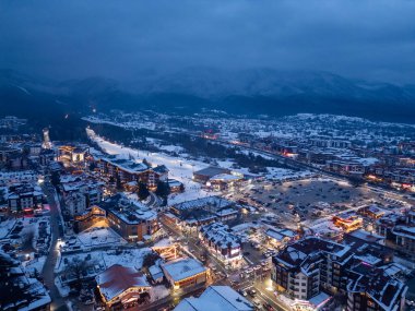 Nestled in the mountains, this town features charming architecture blanketed in snow, with lights reflecting the tranquility of the winter evening. The surrounding peaks create a stunning backdrop. clipart