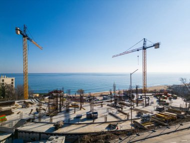 Bulgaristan 'ın Varna kenti yakınlarındaki Kabakum Sahili' nde inşa halindeki yeni otel veya konut kompleksi. Kule vinçleri, metal yapılar ve deniz manzarası bu canlı, güneşli şantiyeyi tanımlar..
