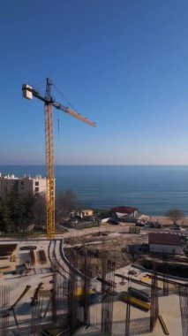 Bulgaristan 'ın Varna kenti yakınlarındaki Kabakum Sahili' nde inşa halindeki yeni otel veya konut kompleksi. Kule vinçleri, metal yapılar ve deniz manzarası bu canlı, güneşli şantiyeyi tanımlar..