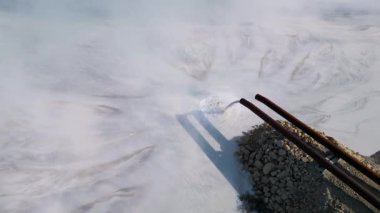 Bir çimento fabrikasının gölü borularla görünür bir şekilde suya atık boşaltıyor. Bu endüstriyel akıntı, kasıtlı olarak boşaltılması ve çevredeki çevresel etkilerinin altını çiziyor.