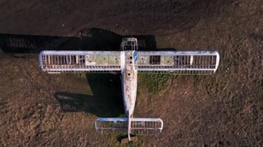 Antonov An-2 'nin terk edilmiş karesi çimenli bir arazide duruyor. Paslı yapısı ve soyulmuş kanatları, yılların ihmalkârlığını gözler önüne seriyor. Havacılık tarihi ve çürümenin unutulmaz bir kalıntısı olarak hizmet veriyor..
