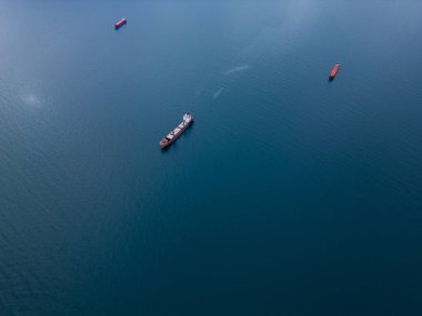 An aerial perspective of cargo ships floating on the open sea, representing global trade and maritime transport. The calm water and scattered vessels create a serene yet dynamic view of the shipping clipart