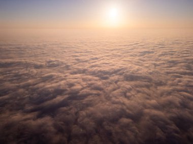 Uçsuz bucaksız bir bulut denizi üzerinde nefes kesici bir gün doğumu manzarası. Altın ışık, yuvarlanan sisin üzerine yumuşak bir parıltı saçar. Pürüzsüz bir hareket ve yüksek irtifa ile rüya gibi, sakin bir atmosfer yaratır.