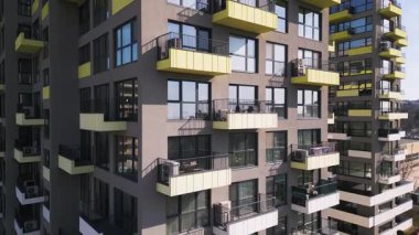 Eşsiz mimari cepheleri olan renkli konut binalarının hava aracı görüntüsü, modern şehir tasarımı ve canlı şehir manzarası sergileniyor..