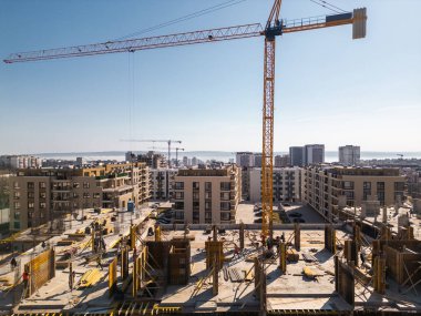 Şehir manzarası, devam eden inşaat projeleri ve tamamlanmış konut binaları. Kentsel kalkınma, genişleme ve modern altyapının büyümesini vurguluyor.