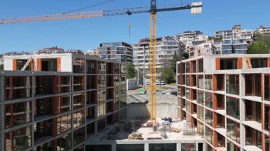 İnşaat halindeki modern konut binaları iskele ve vinçlerle aydınlık bir günde çekildi..