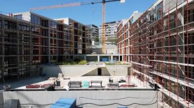 İnşaat halindeki modern konut binaları iskele ve vinçlerle aydınlık bir günde çekildi..