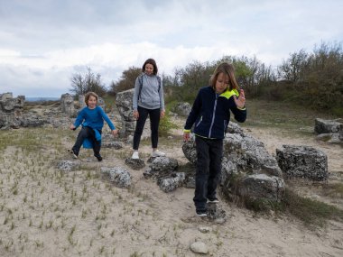 Anne ve iki çocuk kurak, yarı çöl bir arazide kayalık araziyi keşfediyorlar. Çocuklar taş formasyonlarıyla oynarken anne izliyor ve birlikte açık hava macerasının tadını çıkarıyor..