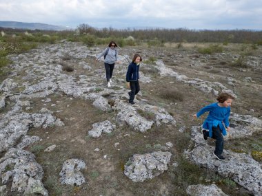 Anne ve iki çocuk kurak, yarı çöl bir arazide kayalık araziyi keşfediyorlar. Çocuklar taş formasyonlarıyla oynarken anne izliyor ve birlikte açık hava macerasının tadını çıkarıyor..