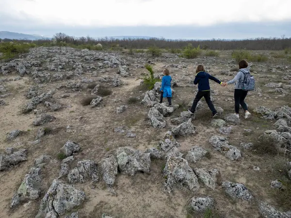 Anne ve iki çocuk kurak, yarı çöl bir arazide kayalık araziyi keşfediyorlar. Çocuklar taş formasyonlarıyla oynarken anne izliyor ve birlikte açık hava macerasının tadını çıkarıyor..