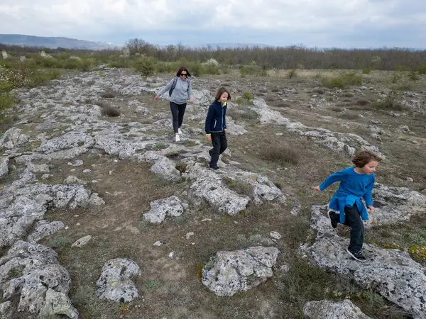 Anne ve iki çocuk kurak, yarı çöl bir arazide kayalık araziyi keşfediyorlar. Çocuklar taş formasyonlarıyla oynarken anne izliyor ve birlikte açık hava macerasının tadını çıkarıyor..