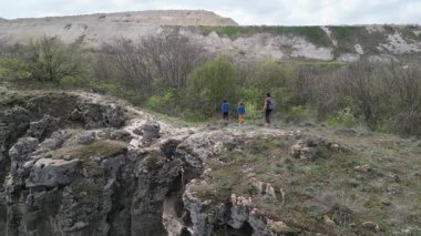 Anne ve iki çocuk bulutlu bir günde vahşi doğada yürüyüş yapıyorlar. Çalılarla ve kayalarla çevrili çimenli bir tepeye çıkıyorlar ve doğal bir çevrede birlikte vakit geçiriyorlar..