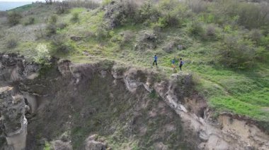 Anne ve iki çocuk bulutlu bir günde vahşi doğada yürüyüş yapıyorlar. Çalılarla ve kayalarla çevrili çimenli bir tepeye çıkıyorlar ve doğal bir çevrede birlikte vakit geçiriyorlar..