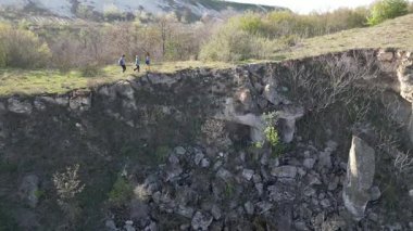 Güneşli bir günde bir anne ve iki çocuk manzaralı bir uçurumun kenarında yürüyüş yaparlar. Manzara engebeli ve vahşi, dramatik kaya oluşumları ve yeşil bahar bitkileriyle.