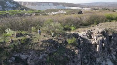 Güneşli bir günde bir anne ve iki çocuk manzaralı bir uçurumun kenarında yürüyüş yaparlar. Manzara engebeli ve vahşi, dramatik kaya oluşumları ve yeşil bahar bitkileriyle.