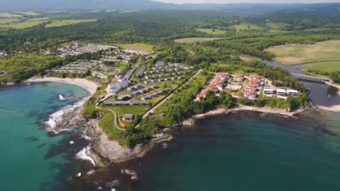 Uçurumlar, turkuaz su, kumlu plajlar, yazlık evler ve yeşil ormanlı Bulgar kıyı şeridinin havadan görünüşü. Modern tatil beldeleri ve doğası olan pitoresk bir yaz merkezi..