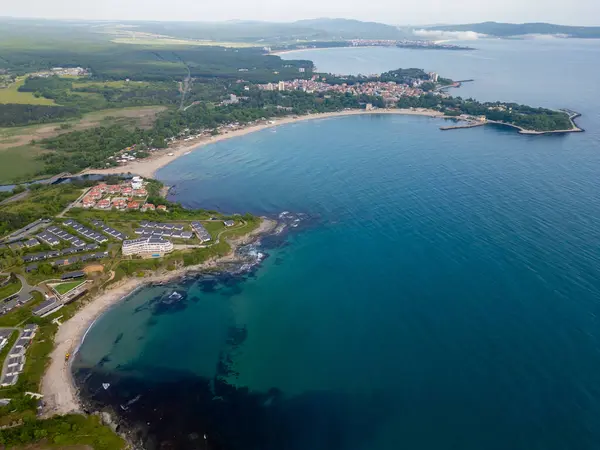 Uçurumlar, turkuaz su, kumlu plajlar, yazlık evler ve yeşil ormanlı Bulgar kıyı şeridinin havadan görünüşü. Modern tatil beldeleri ve doğası olan pitoresk bir yaz merkezi..