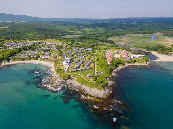 Uçurumlar, turkuaz su, kumlu plajlar, yazlık evler ve yeşil ormanlı Bulgar kıyı şeridinin havadan görünüşü. Modern tatil beldeleri ve doğası olan pitoresk bir yaz merkezi..