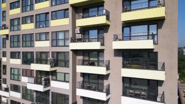 Renkli balkonları olan modern apartman binası ön cephe boyunca yakın uçakla uçan bir dron tarafından vuruldu. Çağdaş mimari ve yerleşim yeri yaşam tarzı.