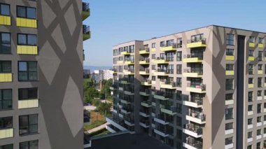 Renkli balkonları olan modern apartman binası ön cephe boyunca yakın uçakla uçan bir dron tarafından vuruldu. Çağdaş mimari ve yerleşim yeri yaşam tarzı.