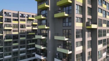 Renkli balkonları olan modern apartman binası ön cephe boyunca yakın uçakla uçan bir dron tarafından vuruldu. Çağdaş mimari ve yerleşim yeri yaşam tarzı.