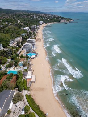 Bulgaristan 'ın Varna kenti yakınlarındaki Saints Constantine ve Helena' daki sahil manzarası. Açık turkuaz deniz, kumlu sahil, tatil köyleri ve güneşli bir günde yemyeşil çevre..