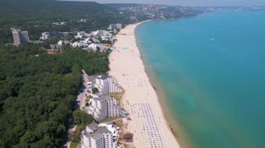 Bulgaristan 'ın Karadeniz kıyısındaki Albena tatil beldesinin havadan manzarası. Yazın geniş kumlu plaj, şemsiye, otel ve ormanlı tepeler..
