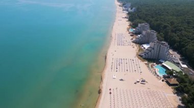 Bulgaristan 'ın Karadeniz kıyısındaki Albena tatil beldesinin havadan manzarası. Yazın geniş kumlu plaj, şemsiye, otel ve ormanlı tepeler..