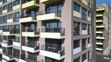 Renkli balkonları olan modern apartman binası ön cephe boyunca yakın uçakla uçan bir dron tarafından vuruldu. Çağdaş mimari ve yerleşim yeri yaşam tarzı.
