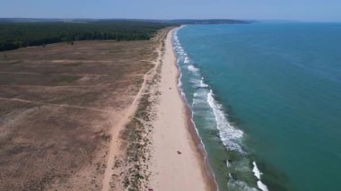 Karadeniz kıyısındaki vahşi Bulgar sahillerinin hava görüntüleri. Saf kum, turkuaz su, yumuşak dalgalar ve güneşli bir yaz gününde yukarıdan yakalanan el değmemiş doğa..