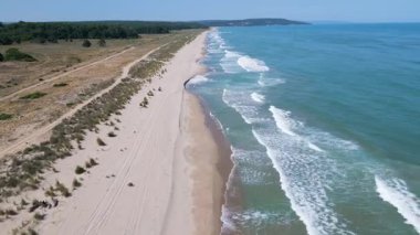Karadeniz kıyısındaki vahşi Bulgar sahillerinin hava görüntüleri. Saf kum, turkuaz su, yumuşak dalgalar ve güneşli bir yaz gününde yukarıdan yakalanan el değmemiş doğa..