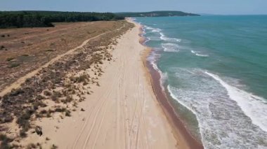 Karadeniz kıyısındaki vahşi Bulgar sahillerinin hava görüntüleri. Saf kum, turkuaz su, yumuşak dalgalar ve güneşli bir yaz gününde yukarıdan yakalanan el değmemiş doğa..